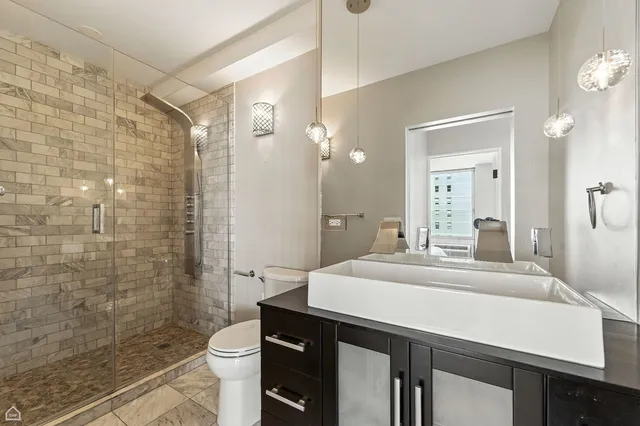 a bathroom with a sink a toilet and shower