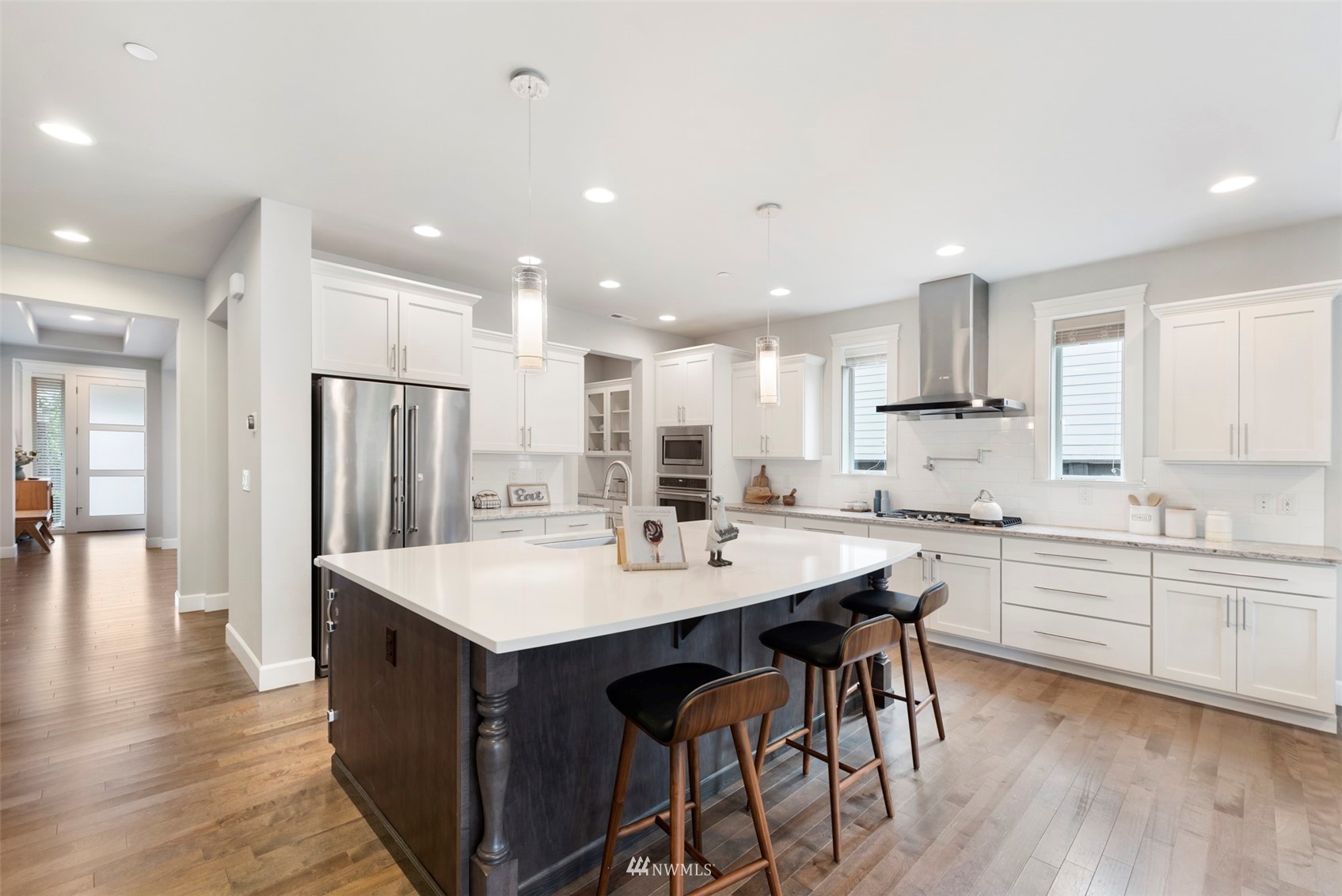 23214 7th Drive Southeast Bothell, WA 98021 - Photo 11 of 37 a kitchen with stainless steel appliances kitchen island granite countertop a table chairs stove and white cabinets