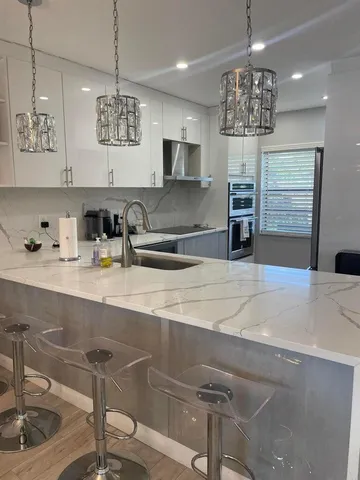 a view of a kitchen with a sink and chandelier