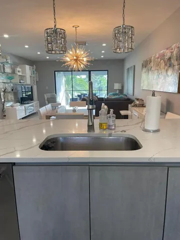 a kitchen with a sink and chandelier