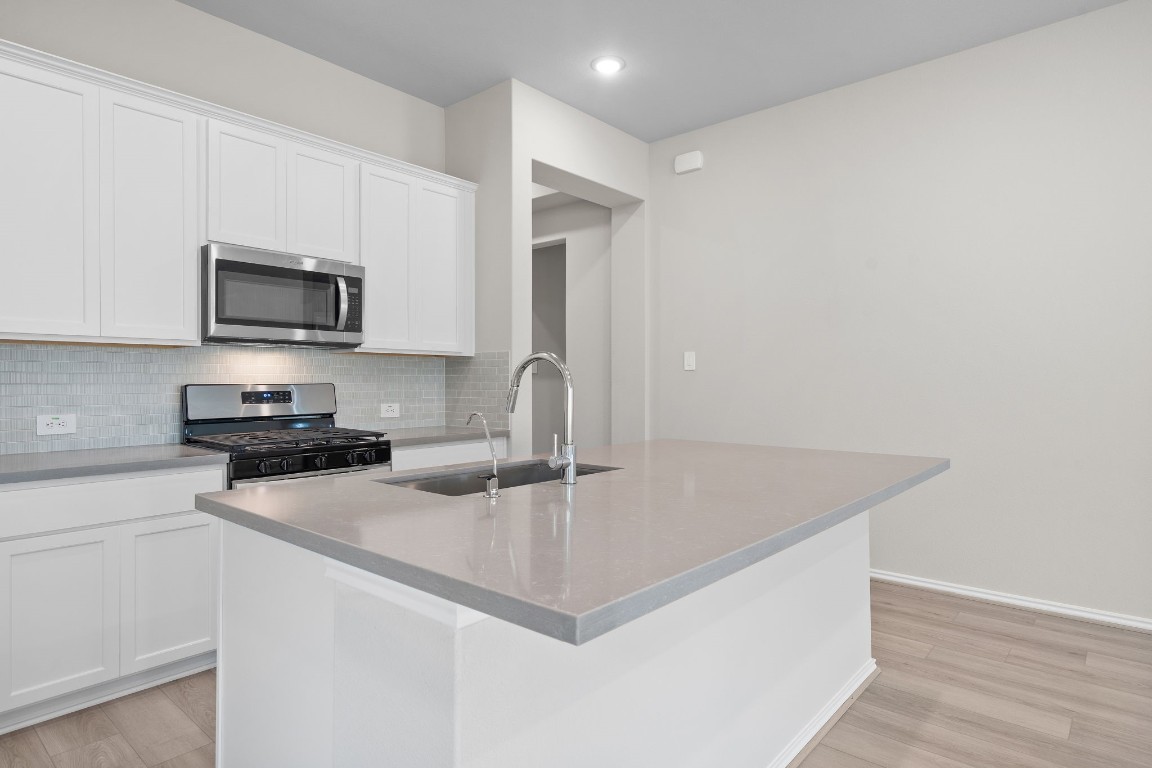 9515 Sierra Crest Lane Porter, TX 77365 - Photo 4 of 38 a kitchen with granite countertop a sink and a microwave