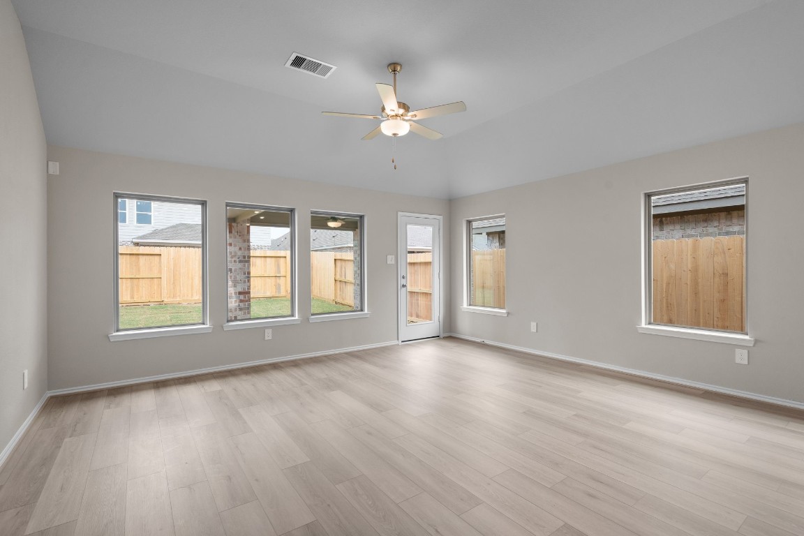 9515 Sierra Crest Lane Porter, TX 77365 - Photo 10 of 38 an empty room with wooden floor chandelier fan and windows