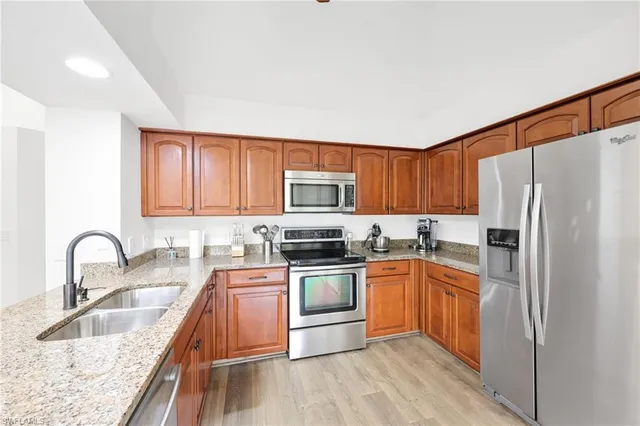 a kitchen with stainless steel appliances granite countertop a sink stove and refrigerator