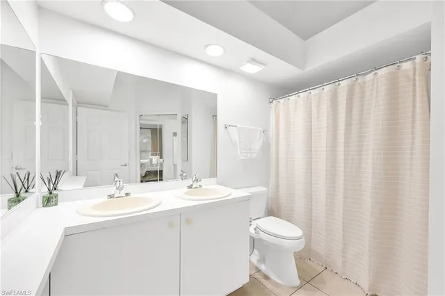 a bathroom with a double vanity sink toilet and a mirror