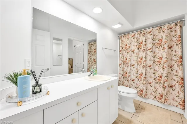 a bathroom with a sink a toilet and shower curtain
