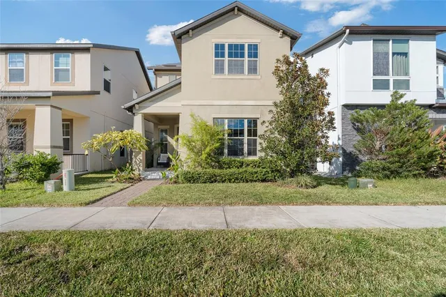 a front view of a house with a yard and potted plants
