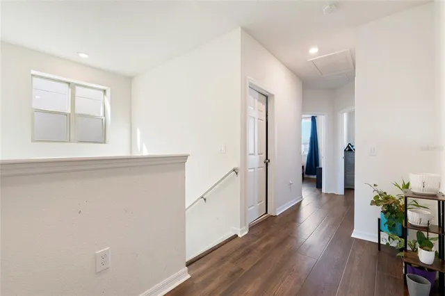 a view of a hallway with wooden floor and staircase