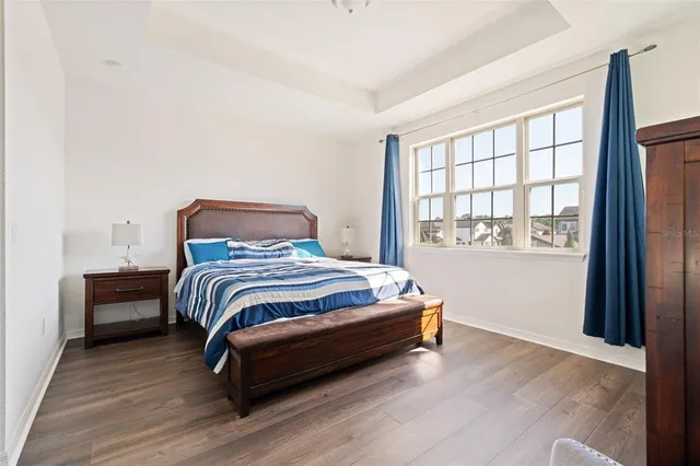 a bedroom with a bed and wooden floor