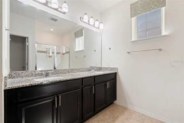a bathroom with a granite countertop sink and a mirror