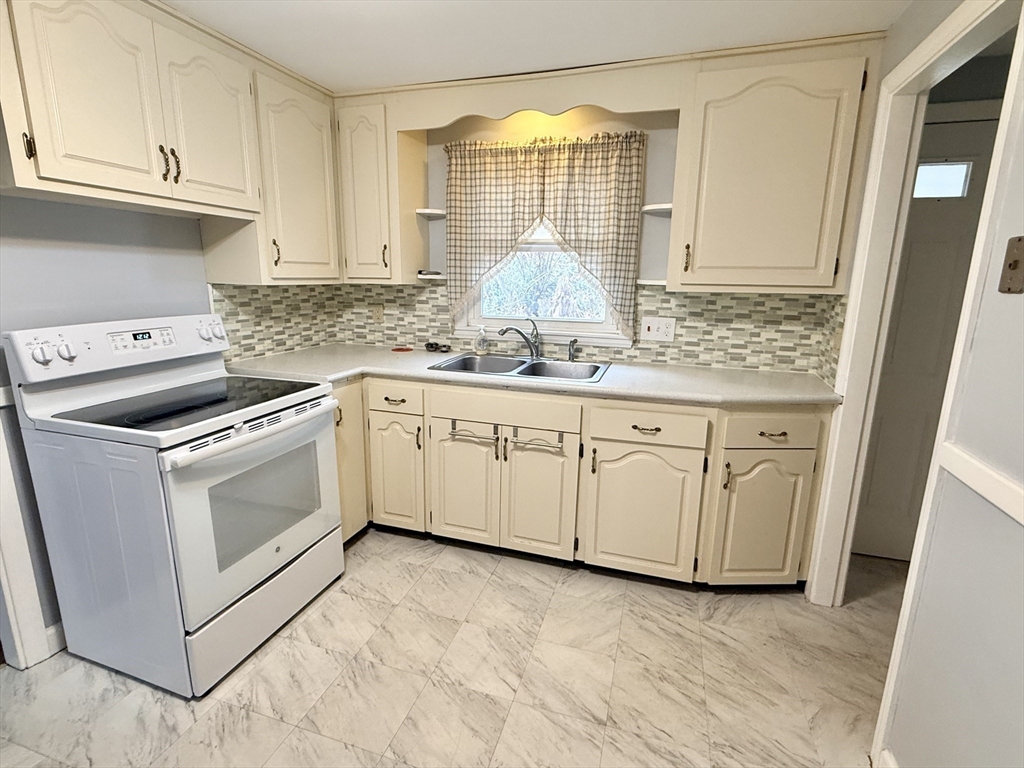 6 Roald Street Worcester, MA 01605 - Photo 4 of 11 a kitchen with granite countertop white cabinets and white appliances