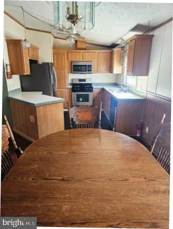 a bedroom with a bed a window and stainless steel appliances
