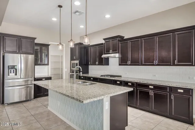 a kitchen with kitchen island a counter top space appliances and a center island