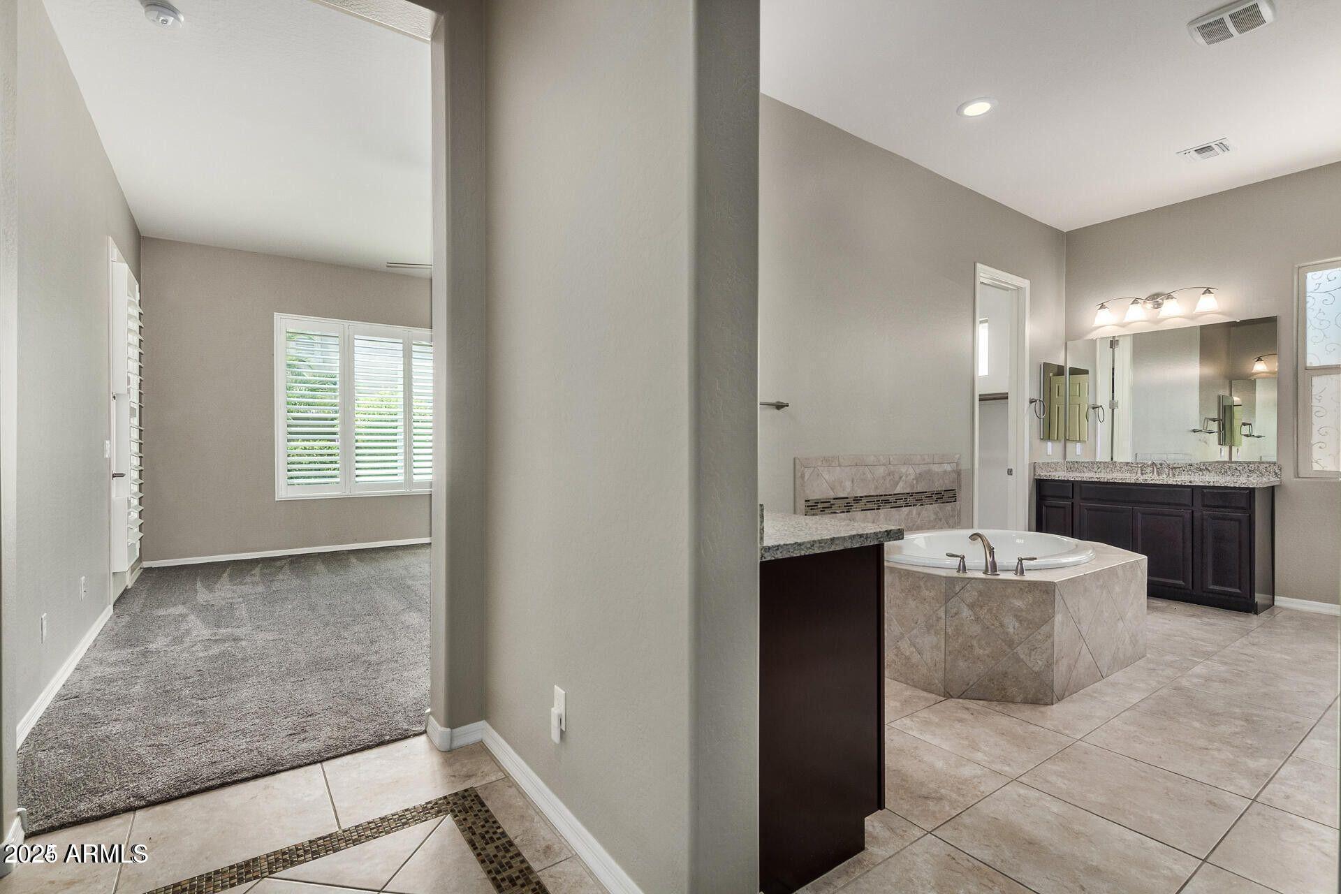 15430 South 183rd Lane Goodyear, AZ 85338 - Photo 22 of 66 a spacious bathroom with a double vanity sink a mirror and a bathtub