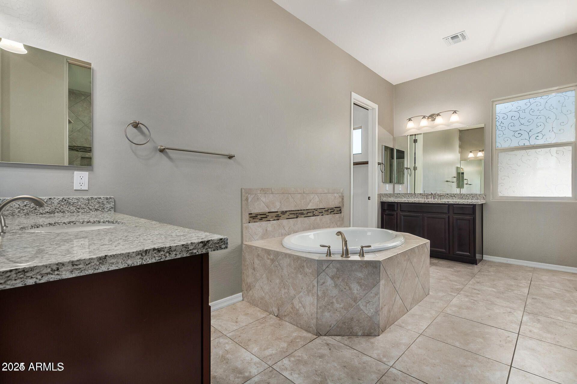 15430 South 183rd Lane Goodyear, AZ 85338 - Photo 23 of 66 a spacious bathroom with a granite countertop sink and a bathtub