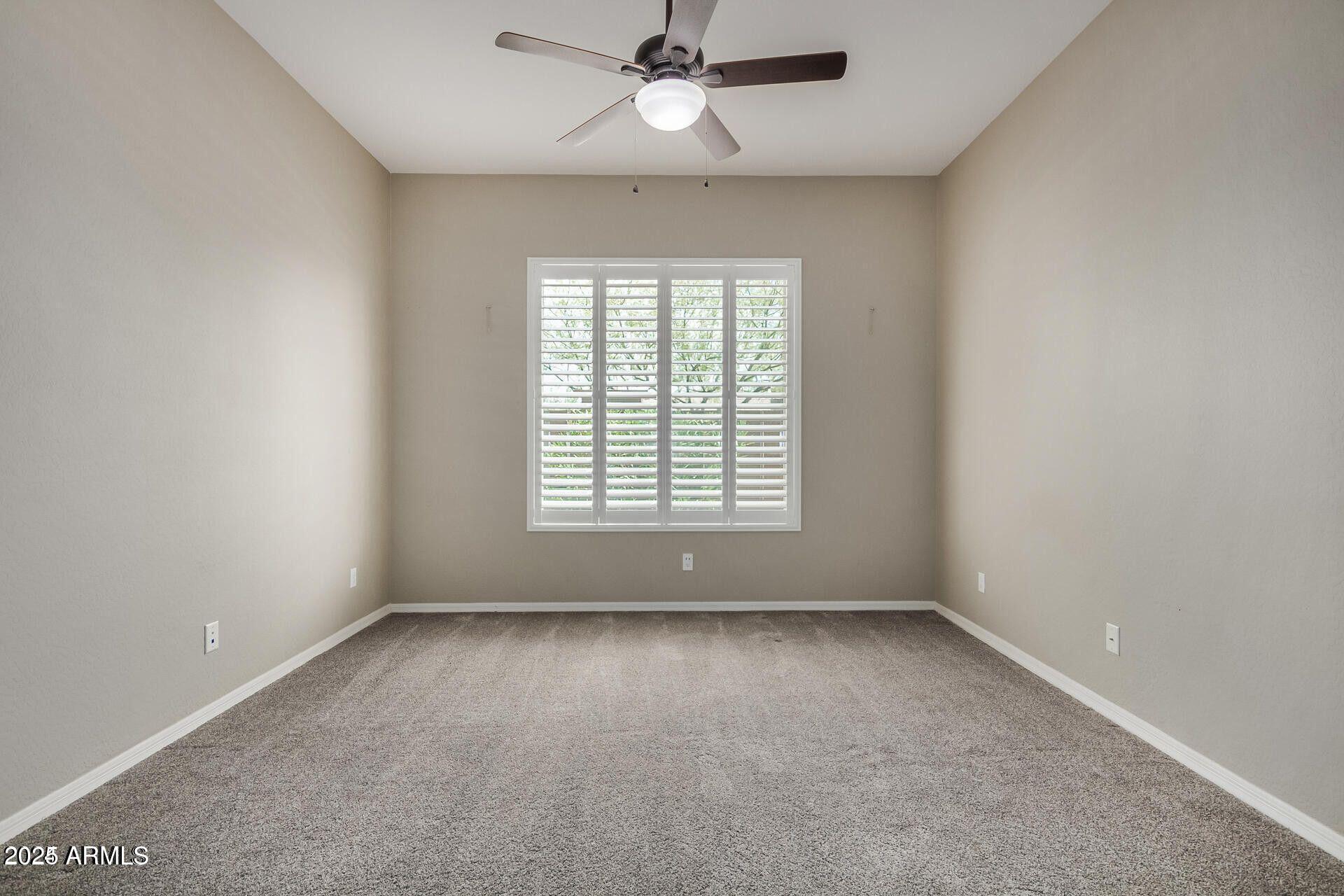 15430 South 183rd Lane Goodyear, AZ 85338 - Photo 7 of 66 an empty room with a window and a fan