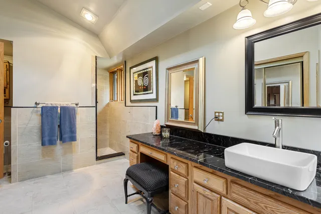 a bathroom with a granite countertop toilet sink and mirror