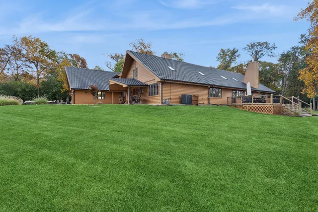 an aerial view of a house with a yard and lake view