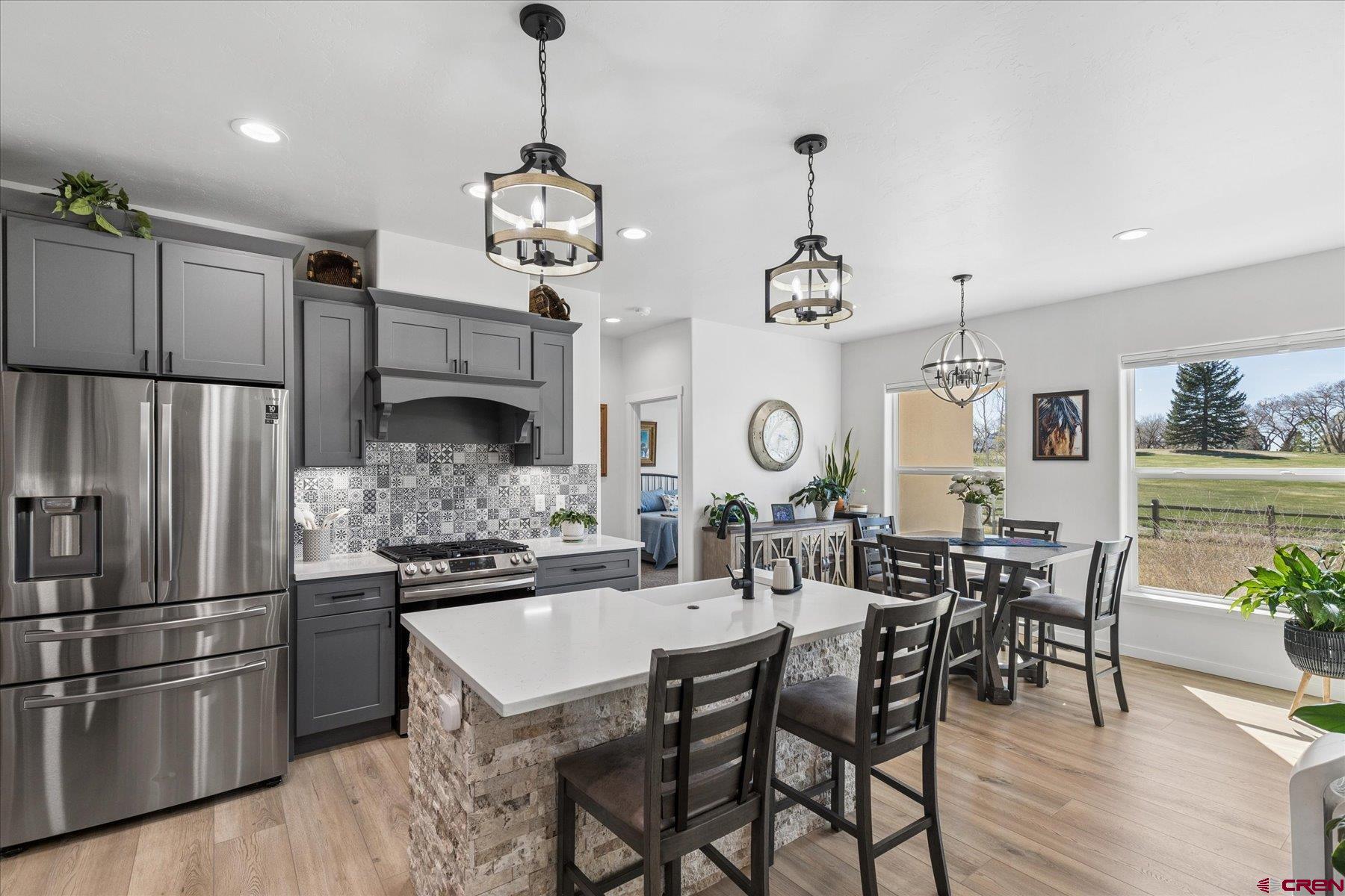 1937 Golf Course Lane Cortez, CO 81321 - Photo 10 of 31 a kitchen with stainless steel appliances kitchen island granite countertop a dining table chairs and white cabinets