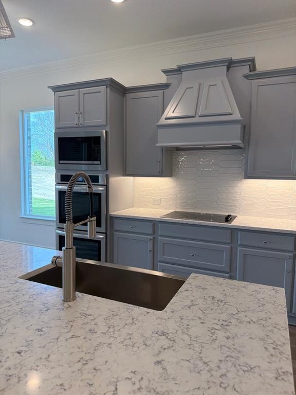 906 Perrin Lane Van Alstyne, TX 75495 - Photo 9 of 14 a kitchen with stainless steel appliances wooden cabinets a stove and a sink