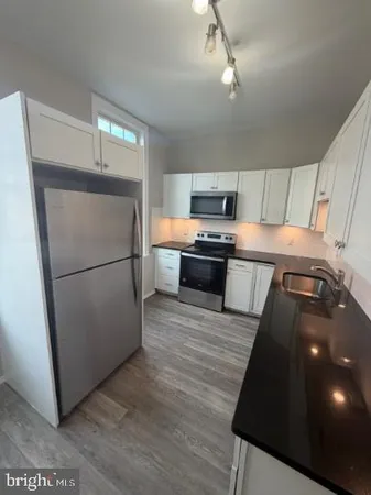 a kitchen with stainless steel appliances a refrigerator sink and microwave