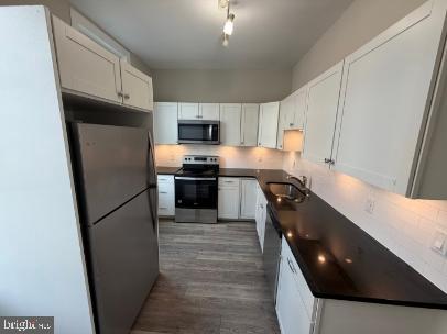 37 Bridge Street, Unit 501 Phoenixville, PA 19460 - Photo 12 of 38 a kitchen with a refrigerator a stove top oven a sink and dishwasher