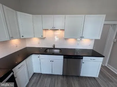 a kitchen with granite countertop white cabinets and white appliances