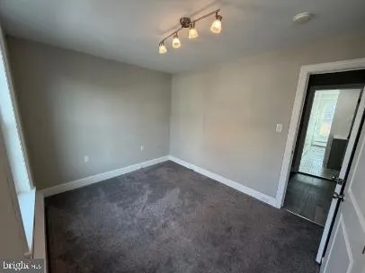 an empty room with a fireplace and windows