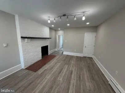 an empty room with wooden floor and fireplace