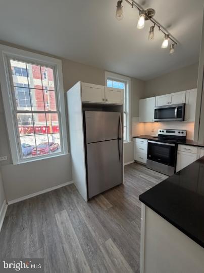 37 Bridge Street, Unit 501 Phoenixville, PA 19460 - Photo 10 of 38 a kitchen with stainless steel appliances granite countertop a refrigerator a stove top oven a sink and dishwasher with wooden floor