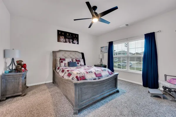 a bed sitting in a bedroom and kitchen