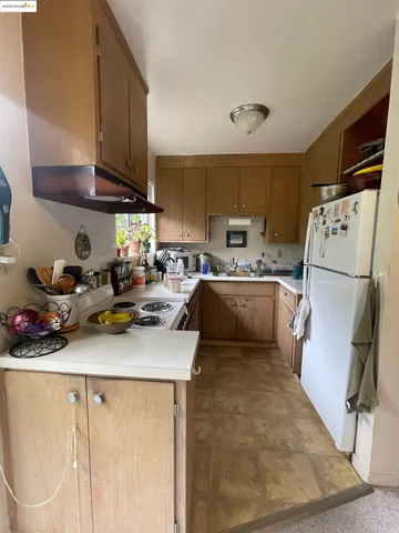 a kitchen with a sink a refrigerator and cabinets