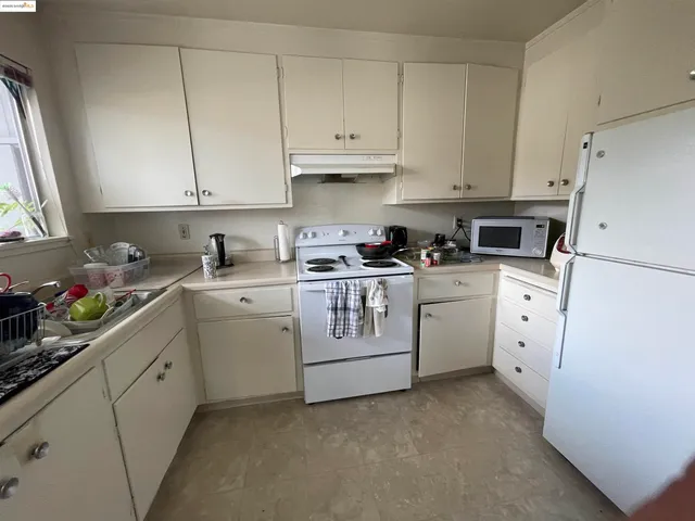 a kitchen with white cabinets and white appliances