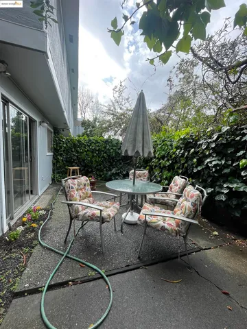 a backyard of a house with fountain table and chairs