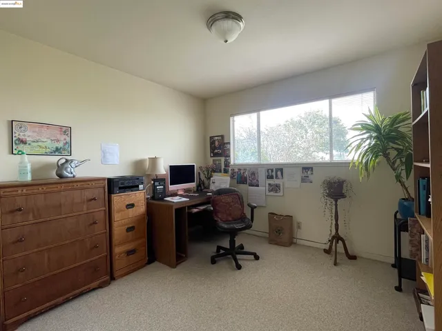 a view of a workspace with furniture and a window