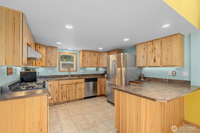a kitchen with stainless steel appliances granite countertop a stove and a refrigerator
