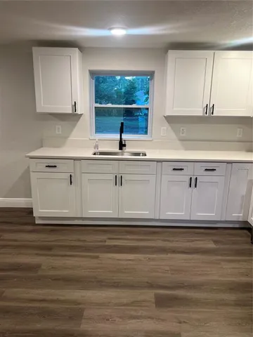 a kitchen with granite countertop a sink cabinets and a window