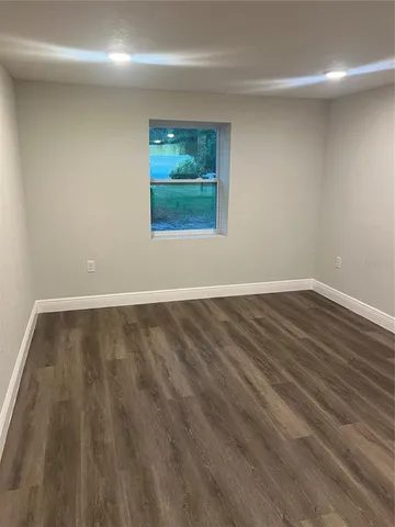 a view of a room with wooden floor and window