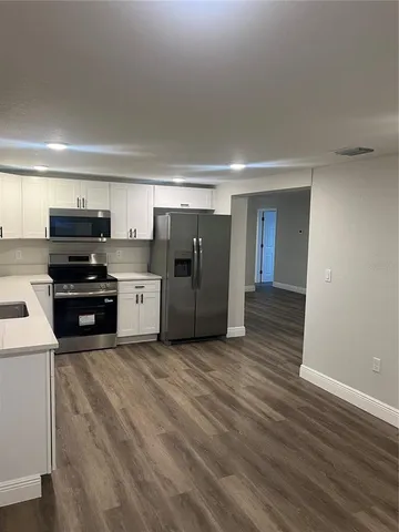 a kitchen with stainless steel appliances a refrigerator and a stove top oven