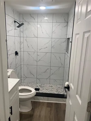 a bathroom with a sink a toilet and shower