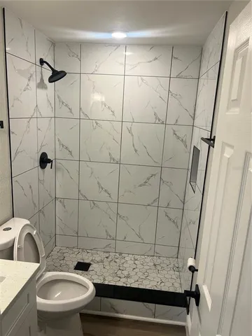 a bathroom with a granite countertop sink toilet and shower