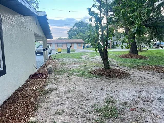 a view of a house with a yard and tree s