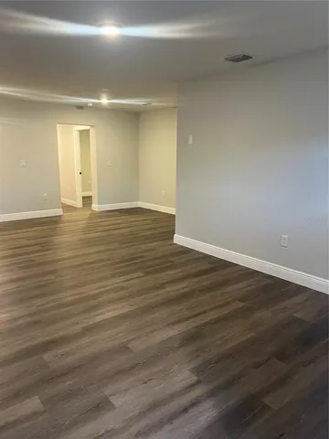 a view of a room with wooden floor and white walls