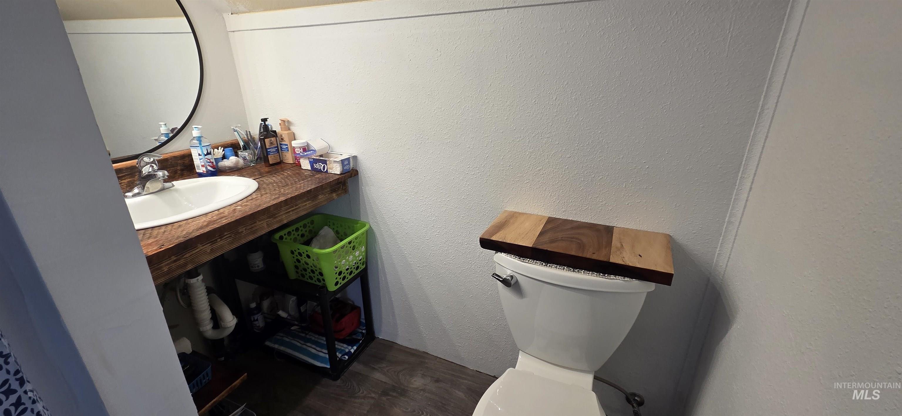 1673 Main Street Pomeroy, WA 99347 - Photo 13 of 26 Half bath featuring a textured wall, vanity, and dark wood finished floors