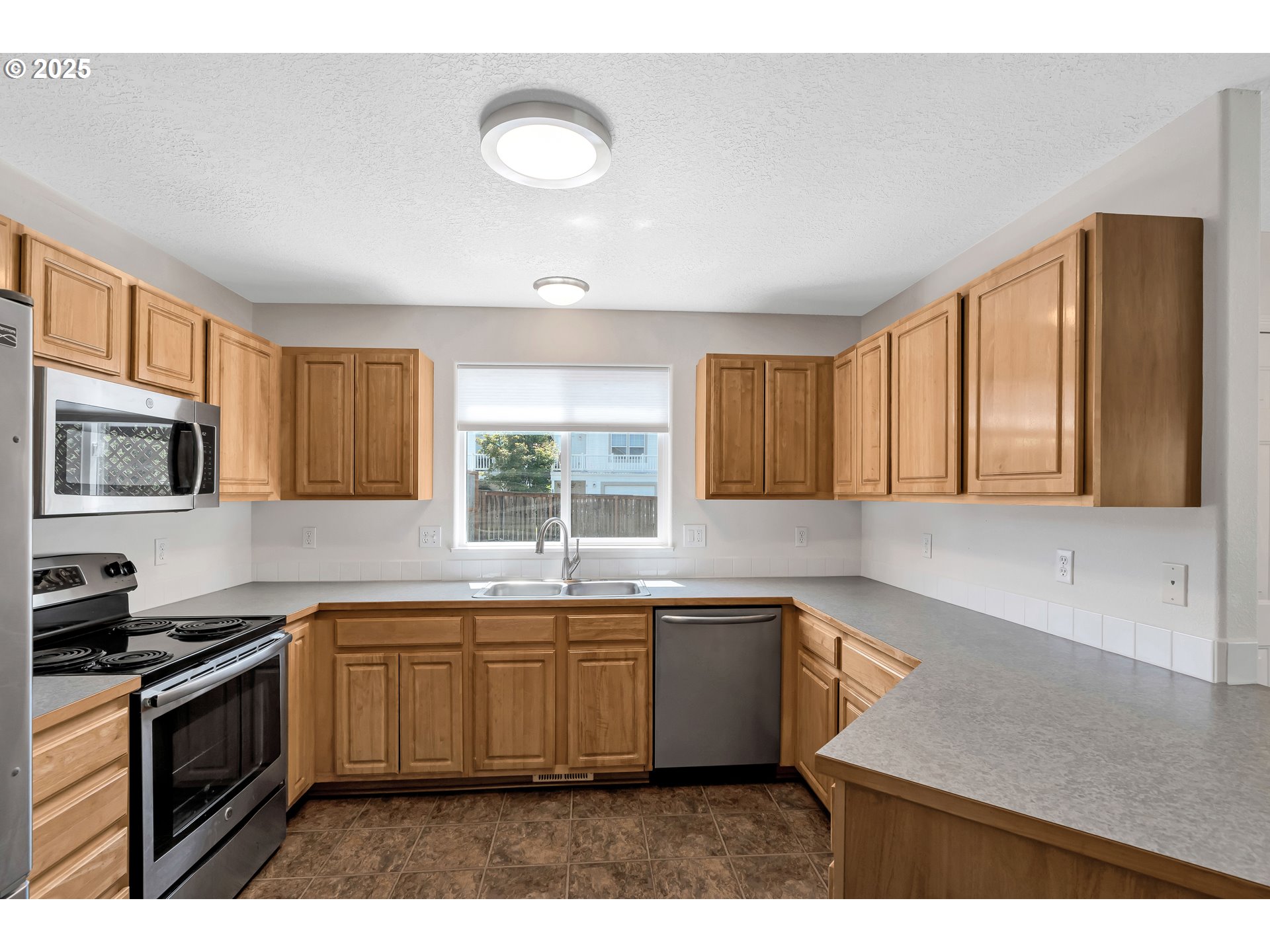 1455 Northeast Jessica Loop Hillsboro, OR 97124 - Photo 11 of 39 a kitchen with a sink window and cabinets