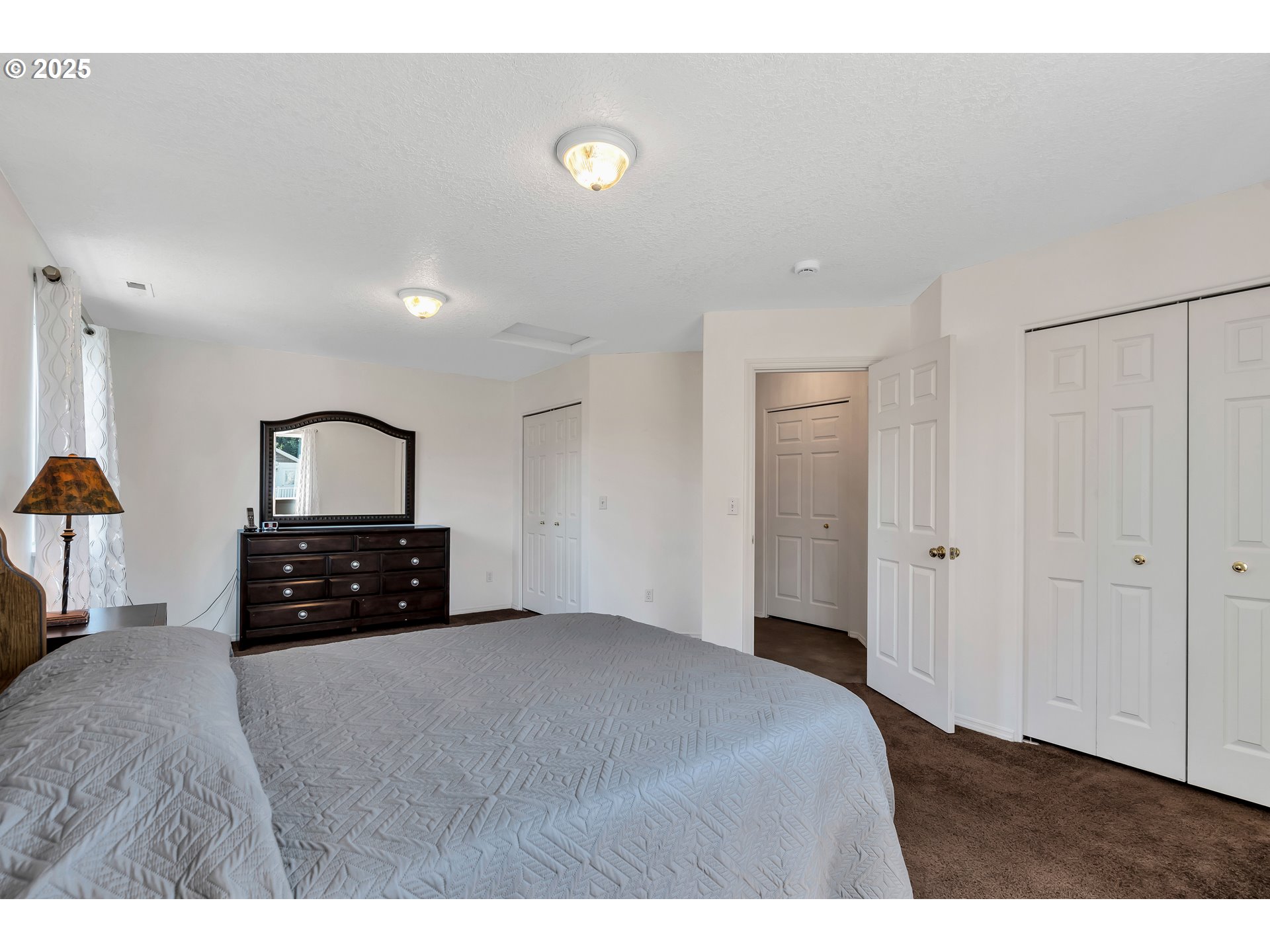 1455 Northeast Jessica Loop Hillsboro, OR 97124 - Photo 25 of 39 a bedroom with a bed and a lamp on dresser