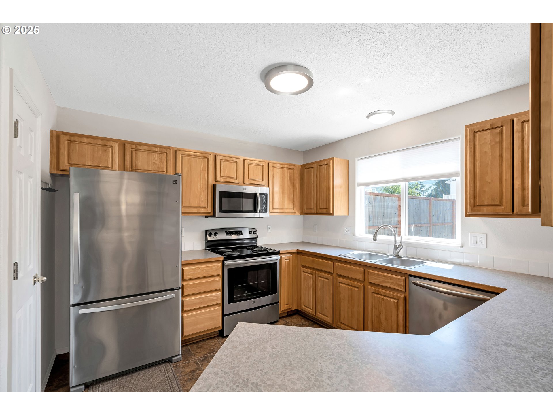 1455 Northeast Jessica Loop Hillsboro, OR 97124 - Photo 10 of 39 a kitchen with stainless steel appliances granite countertop a refrigerator a sink a stove a microwave and island
