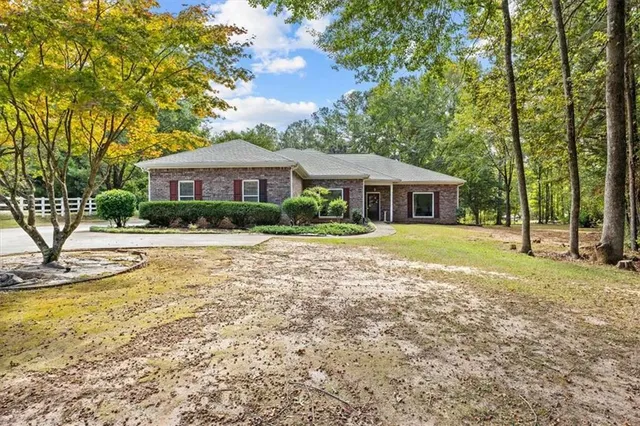 a view of house with yard and outdoor seating