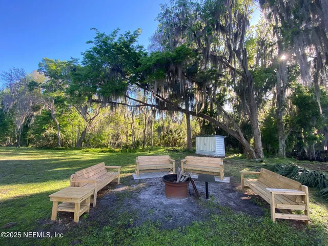 a view of a patio with a table chairs and a backyard