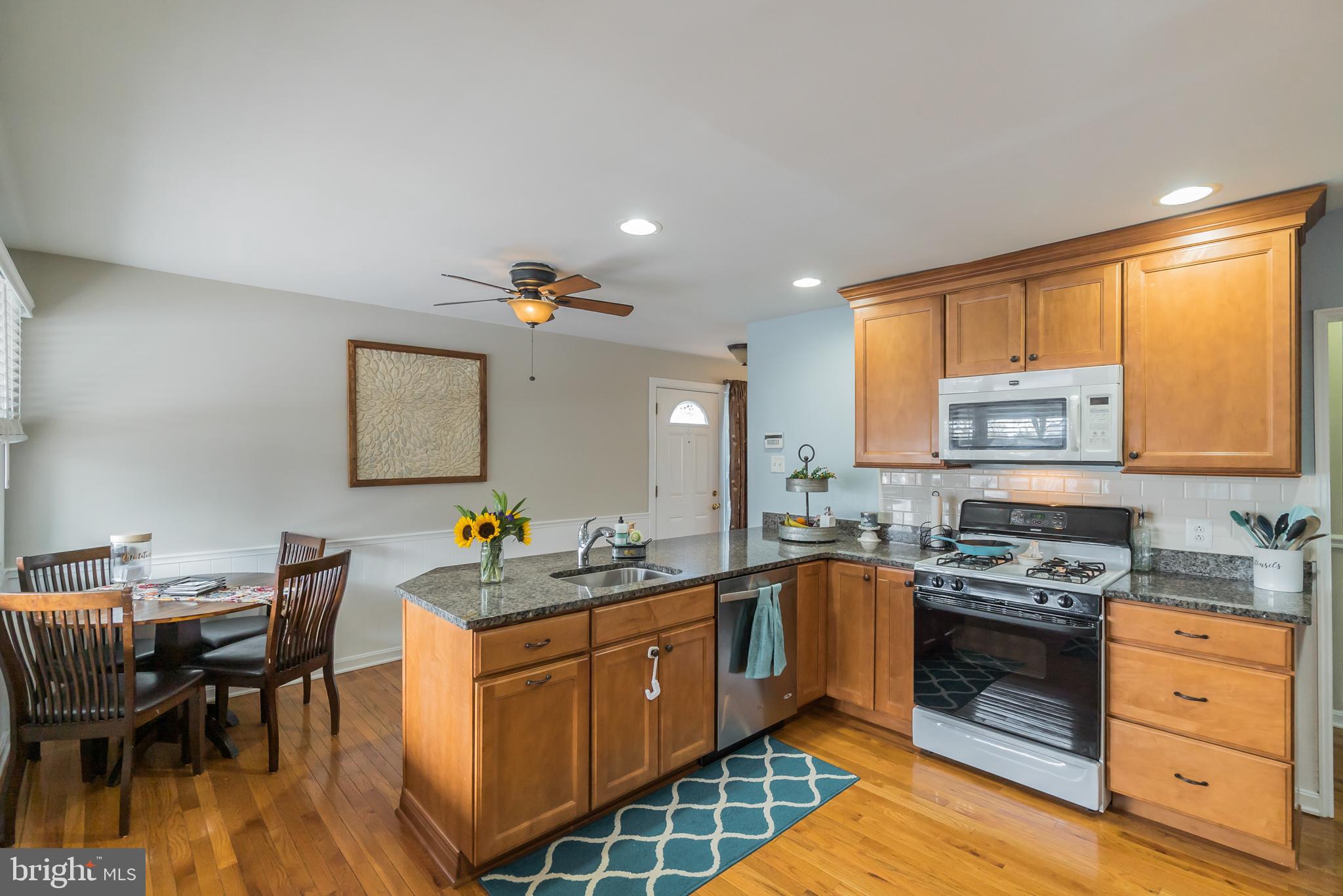 1432 Parklane Road Swarthmore, PA 19081 - Photo 12 of 19 a kitchen with stainless steel appliances kitchen island granite countertop a stove a sink a dining table and chairs
