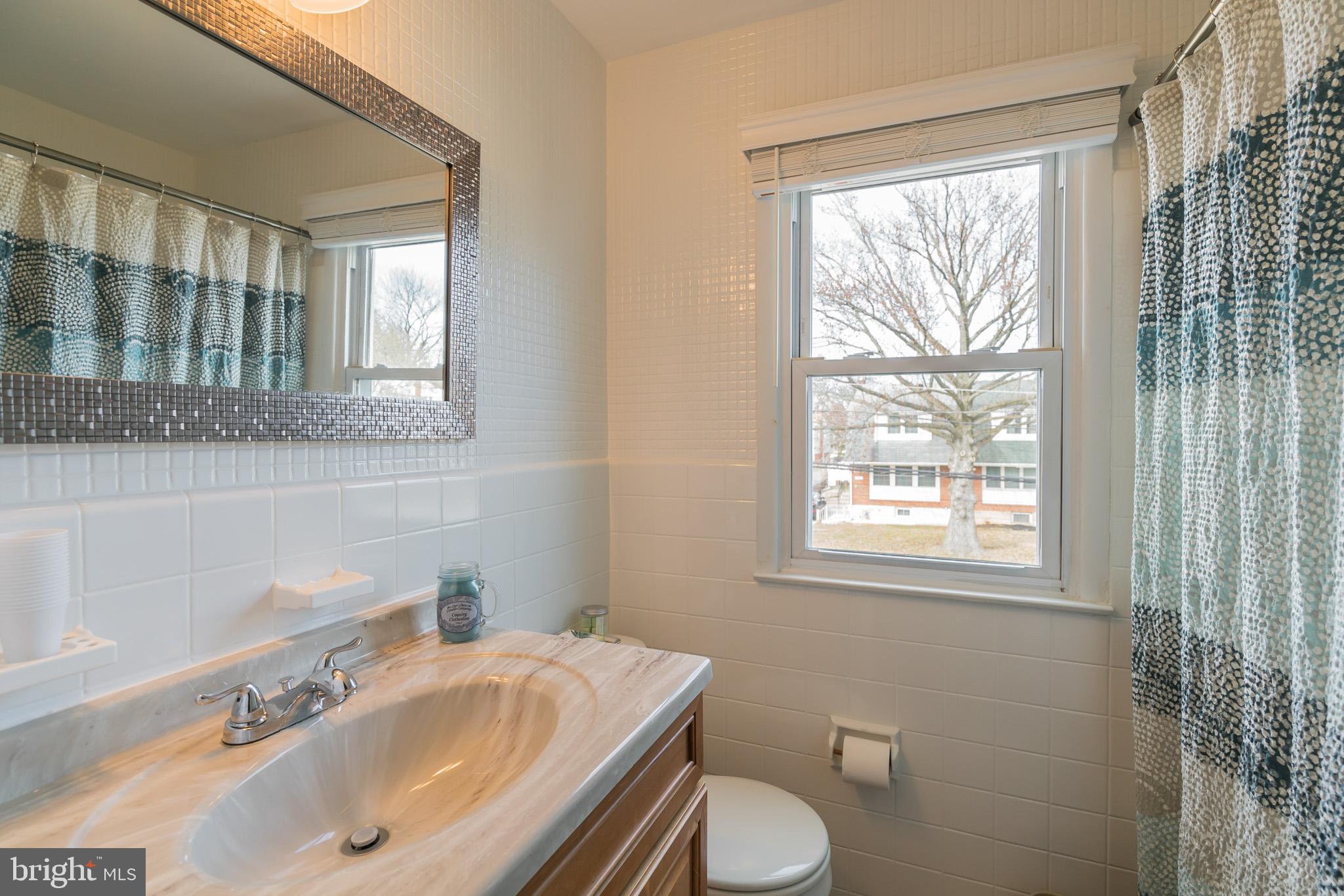 1432 Parklane Road Swarthmore, PA 19081 - Photo 17 of 19 a bathroom with a sink toilet a mirror and next to a window
